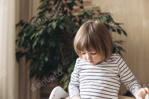Preview: Portrait of pretty caucasian brunette happy smiling little boy posing having fun and playing at home