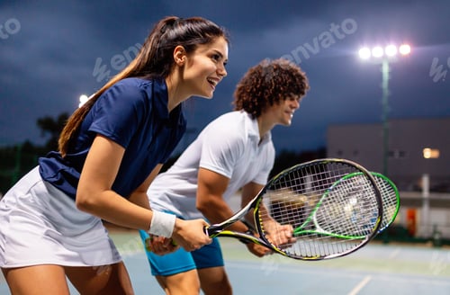 Preview: Beautiful young people are playing tennis as a team on tennis court outdoors. People sport concept