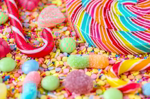 Preview: Close up of candycane and lollipop on a colorful sweets background