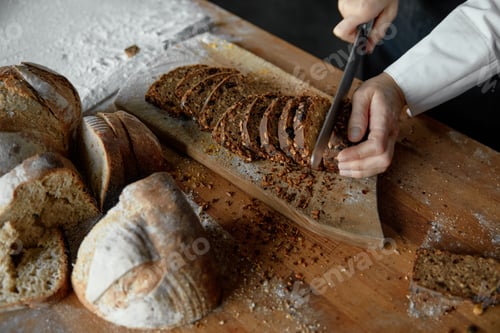 Preview: Closeup middle section woman chef cutting yeast-free sourdough bread