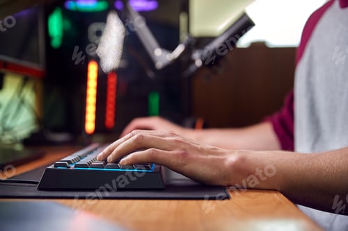 Preview: Close Up Of Hands On Keyboard As Man Games At Home Sitting At Desk With Multiple Monitors
