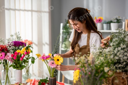 Preview: Asian young florist girl completing beautiful bouquet in flower shop.