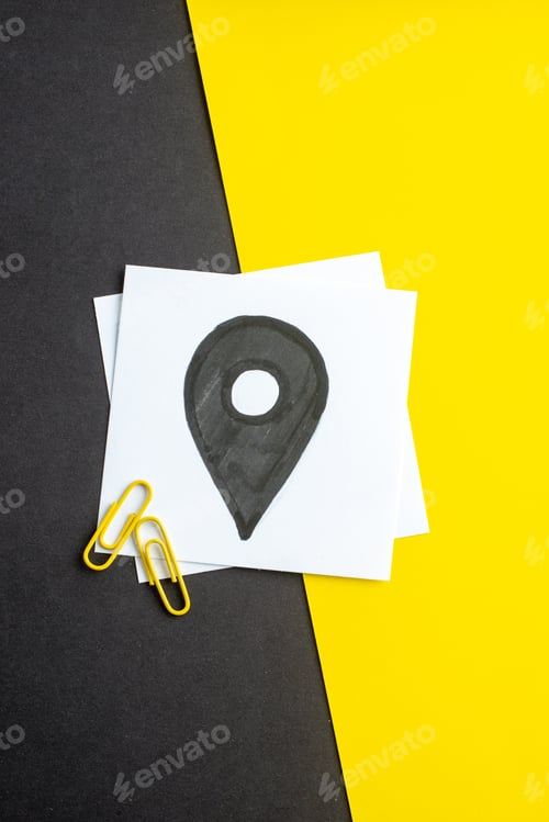 Preview: Top view of black drawing on white blank on dark color yellow mixed color background with free