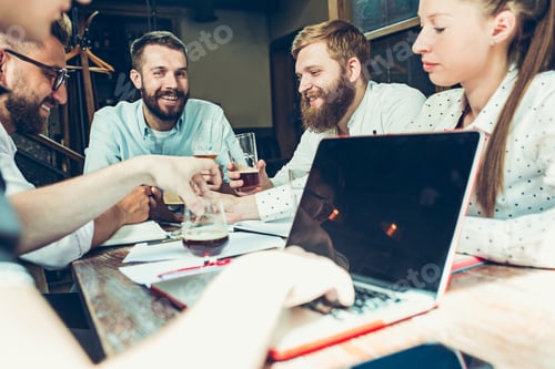 Preview: Young cheerful people smile and gesture while relaxing in pub.