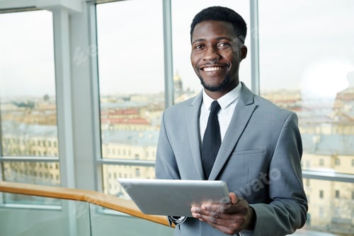Smiling Man Holding Tablet in an Urban Office