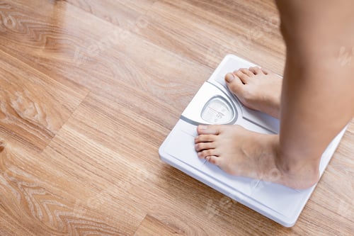 Preview: Female bare feet standing with a scales.