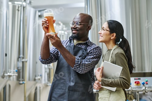 Preview: Couple of engineers examining beer after brewing