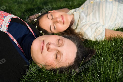 Preview: Mother and daughter sleeping on the grass