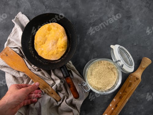 Preview: Homemade corn flatbread meal frying pan in male hand Handmade mexican tortilla wrapping latin recipe