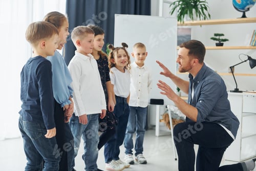 Preview: Storyteller with interesting information. Group of children students in class at school with teacher