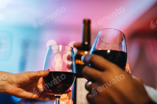 Preview: Couple toasting wine glasses, African American man and Caucasian woman