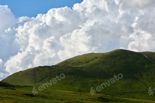 Preview: the view of a cloudy and green mountain in a distance