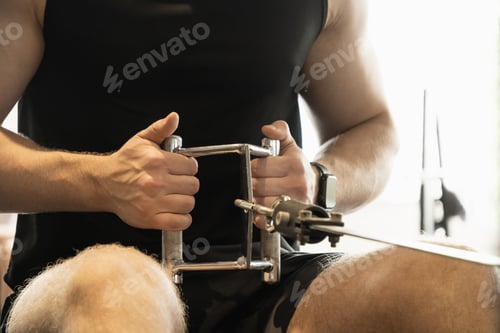 Preview: Man exercising on low row machine.