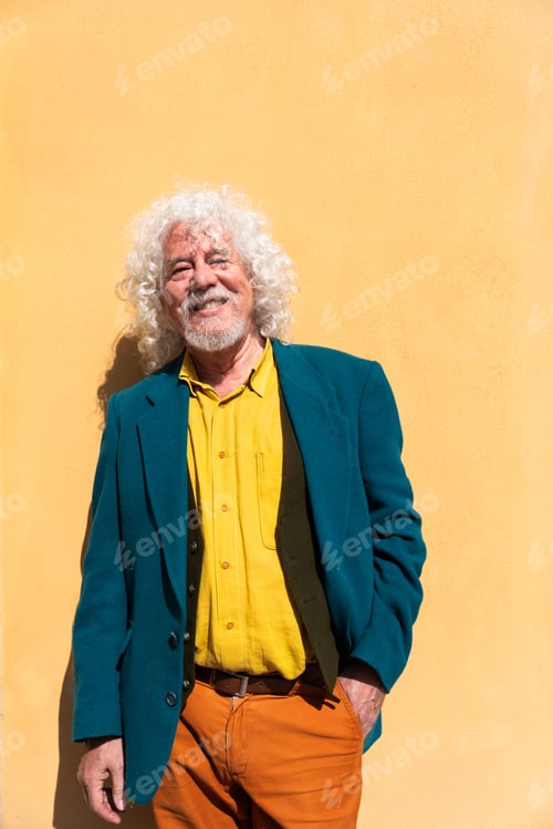 Preview: Portrait of a handsome senior man on colored yellow wall background