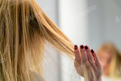 Preview: close-up of a woman's hand touching her hair