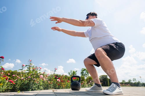 Preview: Sportive man workout with kettlebell outdoor in spring or summer