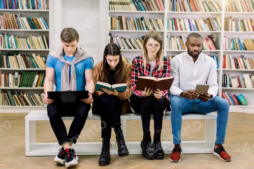 Preview: Book vs e-book and digital gadgets. Young multiethnic smart students, girls and boys, reading in