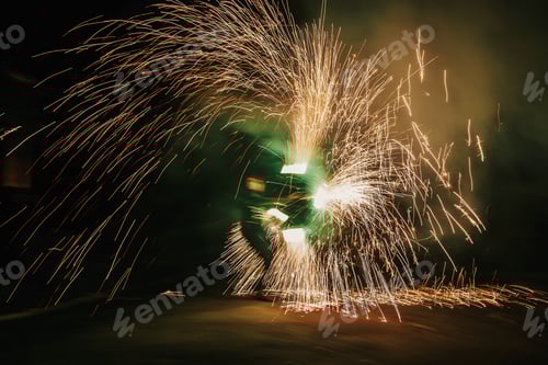 Preview: Fire dancers swing, spinning green fire and man juggling with bright sparks in the night