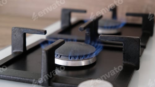 Preview: Close-up blue flames of fire on a gas burner in the kitchen for cooking. Gas flame in a gas boiler.