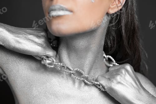 Preview: Beautiful woman with silver paint on her skin and hair breaks the chain around her neck.