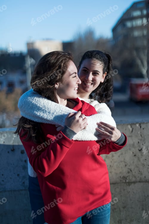 Preview: Excited friends hugging meeting in the street