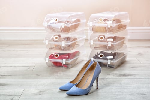 Preview: Pair of female shoes and other footwear in plastic boxes on floor. Storage organization