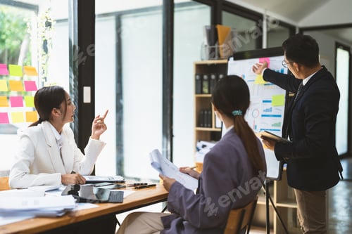 Preview: Business adviser explaining business plan strategy on flipchart to colleagues, male coach or