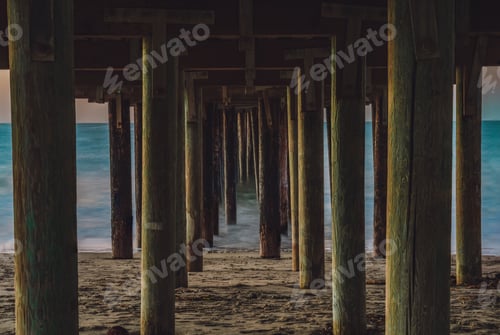 Preview: Picturesque beach scene featuring vibrant sunlight streaming through the pillars