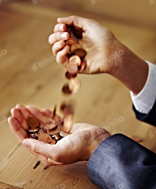 Preview: Playing with money. A closeup of hands pouring coins from one into the other.