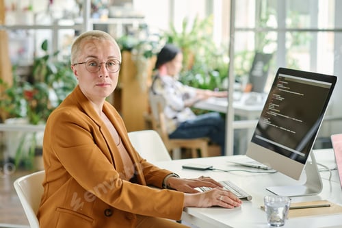 Preview: Female programmer working at office with codes