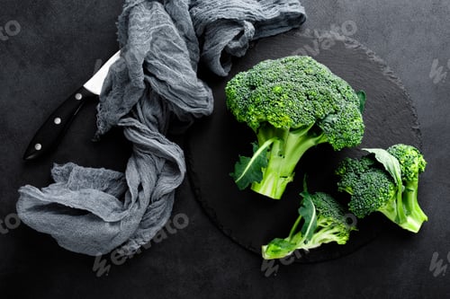 Preview: Fresh broccoli florets on black background, top view