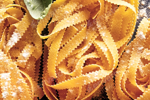 Preview: Tagliatelle. Homemade pasta, basil leaves, flour, pepper, olive oil and cherry tomato on dark black