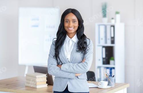 Preview: Portrait of friendly black female manager in formal suit standing with crossed arms at contemporary