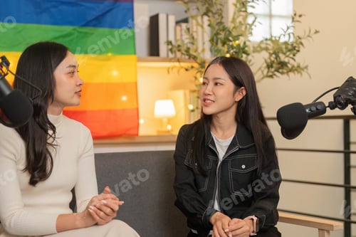 Preview: Empowering Dialogue. Women discussing ideas with pride flag in the background.