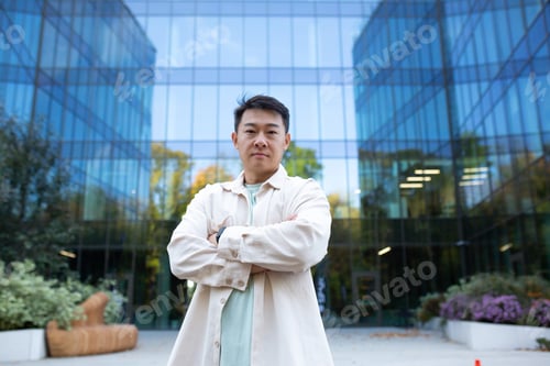 Preview: Portrait of a serious young handsome successful male Asian programmer, freelancer. Standing in