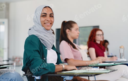 Preview: Portrait of islamic university student sitting in classroom indoors, looking at camera