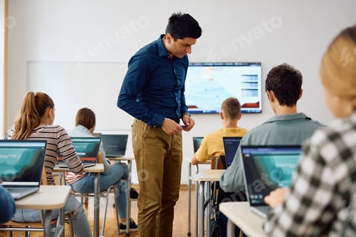 Preview: Computer science teacher and his students during a class at high school.