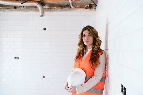 Preview: inspector or architect professional woman holding helmet checking kitchen at construction site