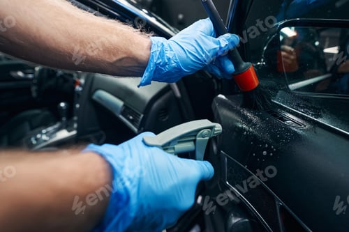 Preview: Auto technician using trigger bottle and brush during car cleaning