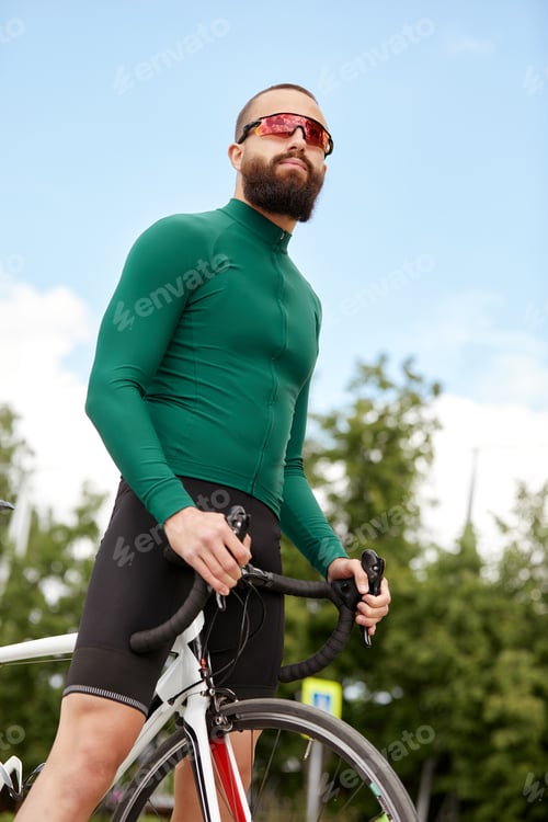 Preview: Close up shot of happy attractive young European man with beard wearing glasses and green sportswear