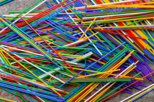 Preview: many multi-colored plastic tubes for cocktail on Colored background, top view