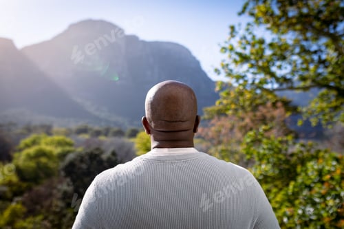 Preview: Back view of african american senior man looking into distance