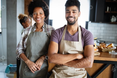 Preview: Beautiful young couple having fun and laughing while cooking in kitchen
