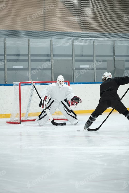 Preview: Hockey player in white sports uniform going to shoot puck during play with rival