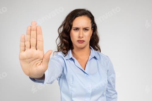 Preview: Confident sad millennial european lady in formal wear making stop sign with hand