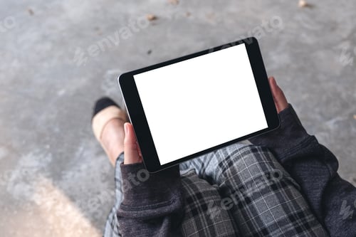 Preview: A woman holding and using black tablet pc with blank white desktop screen