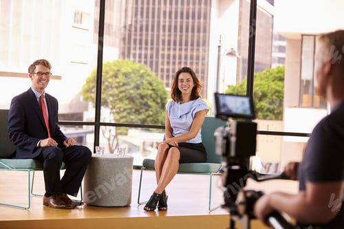 Preview: Smartly dressed man and woman on set for a TV interview