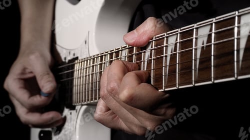 Preview: Close up of musician playing guitars instrument against black background.