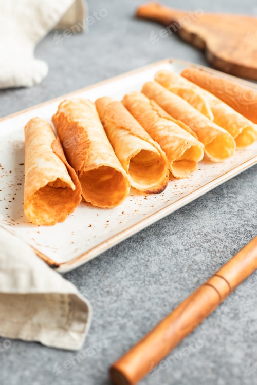 Preview: Traditional Christmas Norwegian cookies Krumkake on a kitchen table.