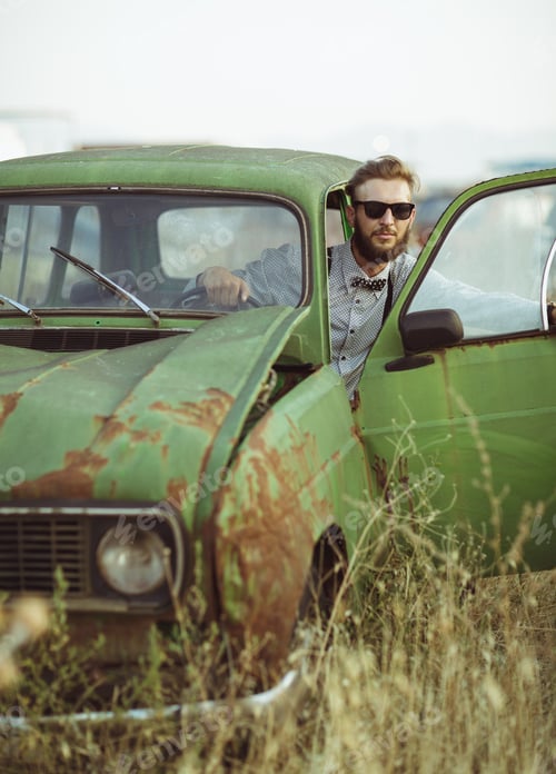 Preview: Young stylish handsome man, wearing shirt and sunglasses, drivin